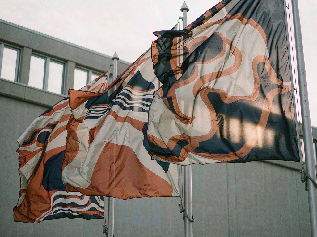Printed polyester flags on flagpoles outside a commercial building