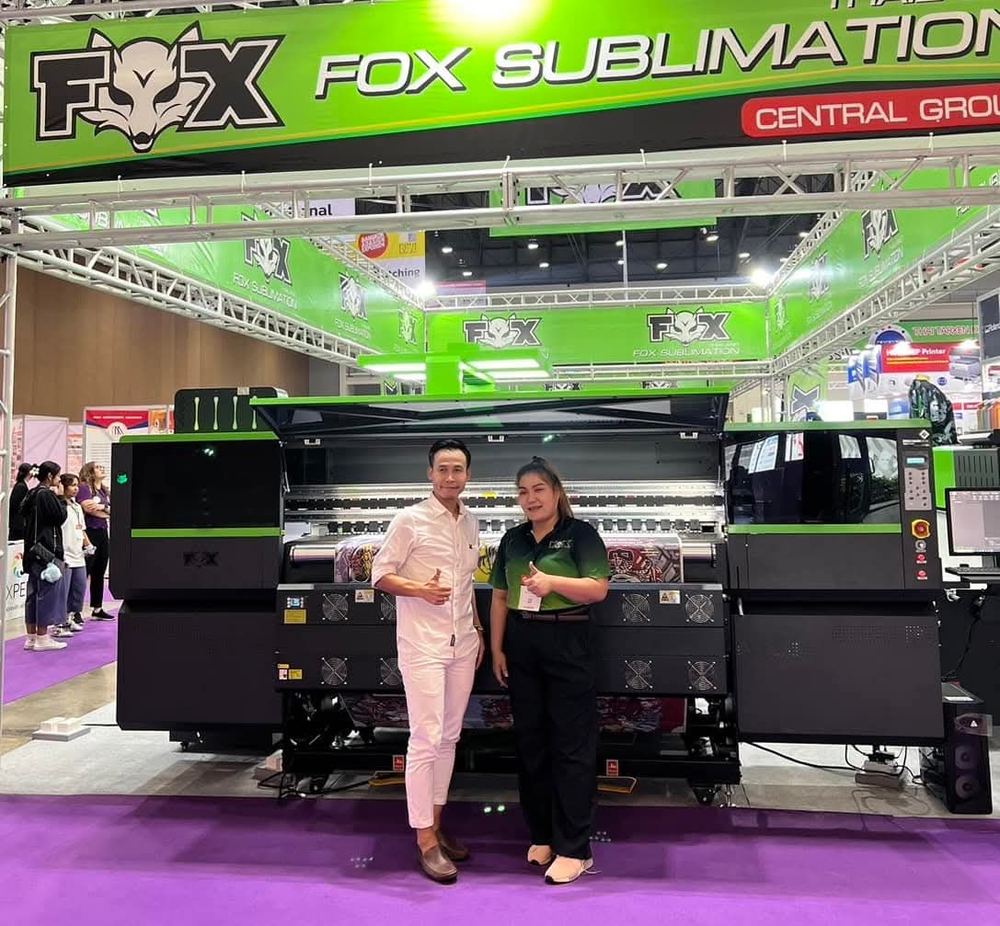 Two people standing in front of a FOX exhibition stand at an industry show