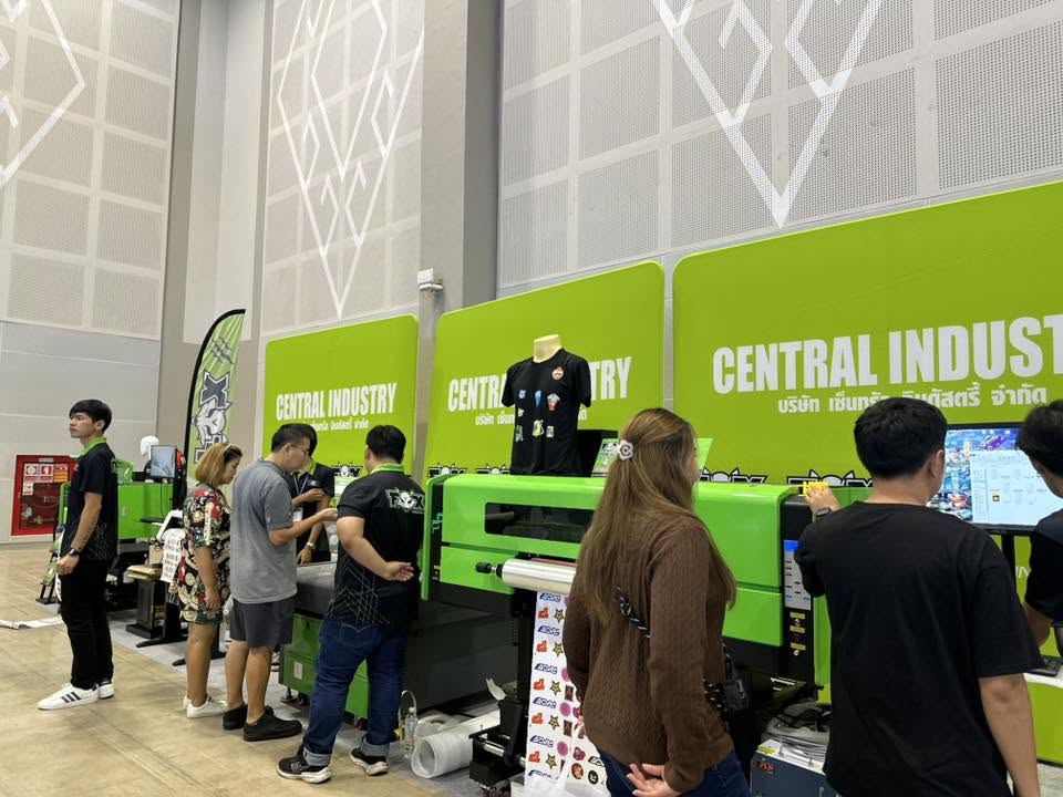 Visitors at a digital printing equipment display with a large printing machine