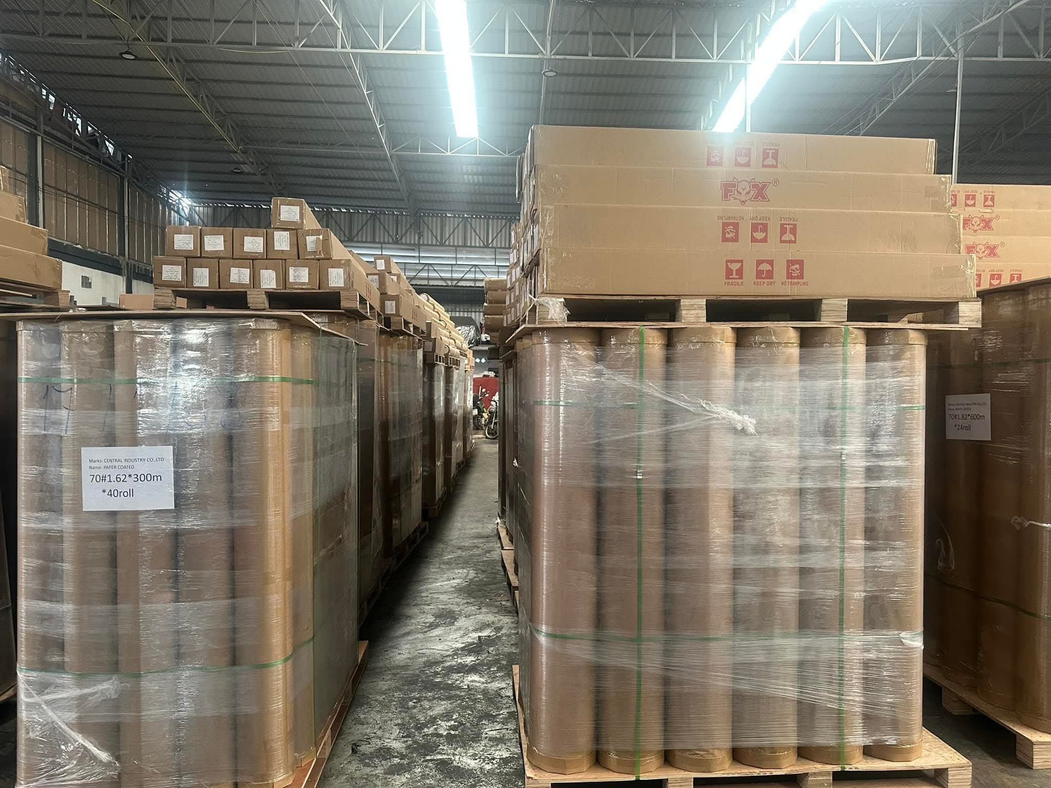A group of people standing at a shipping container filled with bagged roll stock